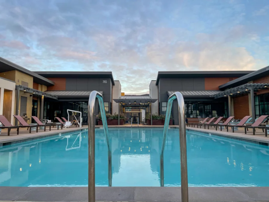 A hotel pool with loungers at dusk